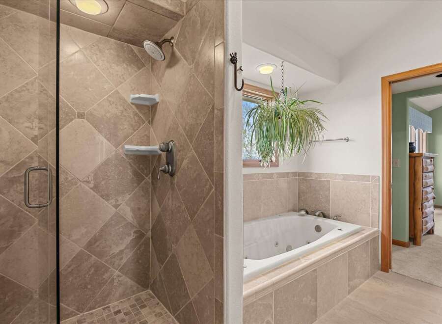 Step into luxury with this stunning bathroom featuring a spacious walk-in shower and a relaxing jacuzzi tub.