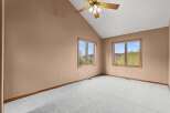 Discover the charm of this inviting bedroom, featuring a vaulted ceiling and ample natural light streaming through the windows.