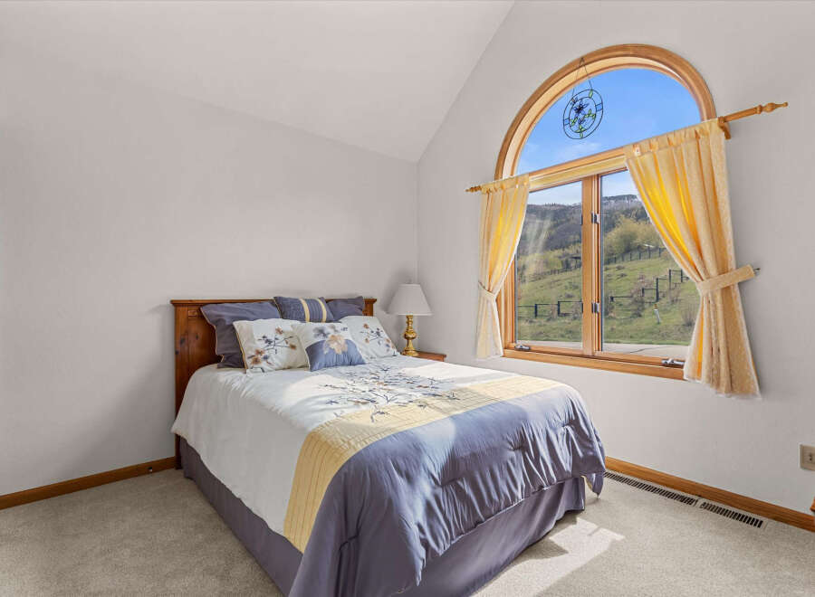 This charming bedroom features a cozy bed with a stylish comforter and decorative pillows, creating a relaxing atmosphere.