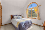 This charming bedroom features a cozy bed with a stylish comforter and decorative pillows, creating a relaxing atmosphere.