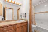 This bathroom features a classic design with a wooden vanity and a large mirror, creating a warm and inviting atmosphere.