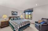This cozy bedroom features a comfortable bed adorned with a beautiful quilt and matching pillows.