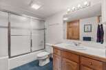 Step into this inviting bathroom, featuring a well-lit vanity area and a convenient shower-tub combo.