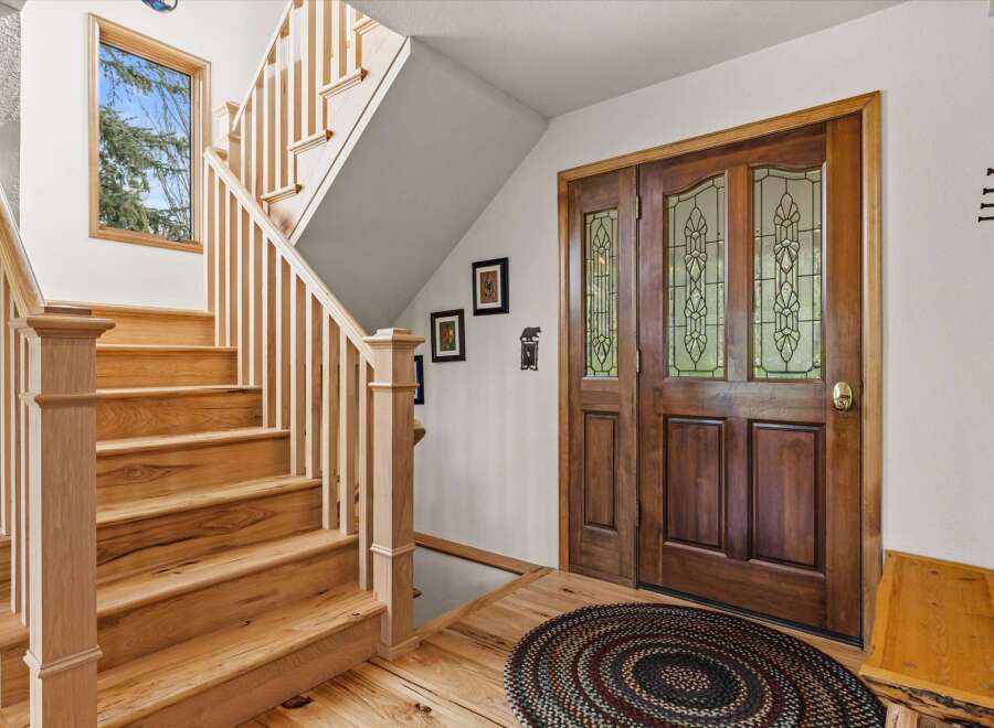 Step into this inviting home with a stunning wooden staircase and a welcoming entryway.