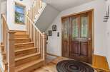 Step into this inviting home with a stunning wooden staircase and a welcoming entryway.
