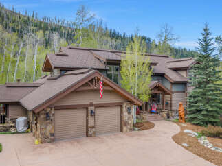 This stunning mountain home boasts a beautiful exterior with a spacious driveway and a two-car garage.