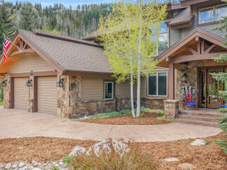 This stunning mountain home boasts a beautiful exterior with a combination of stone and siding, creating a warm and inviting atmosphere.