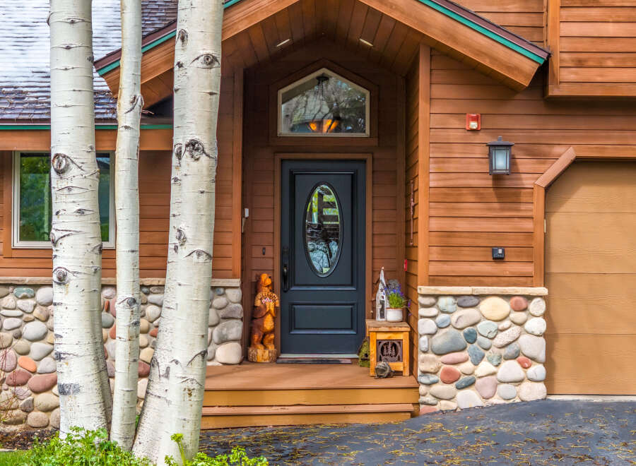 This stunning property boasts a charming exterior with a beautiful wooden facade and a welcoming entrance.
