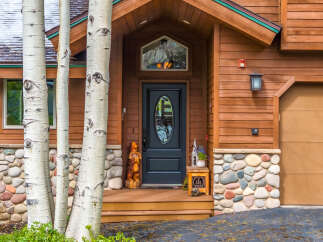 This stunning property boasts a charming exterior with a beautiful wooden facade and a welcoming entrance.