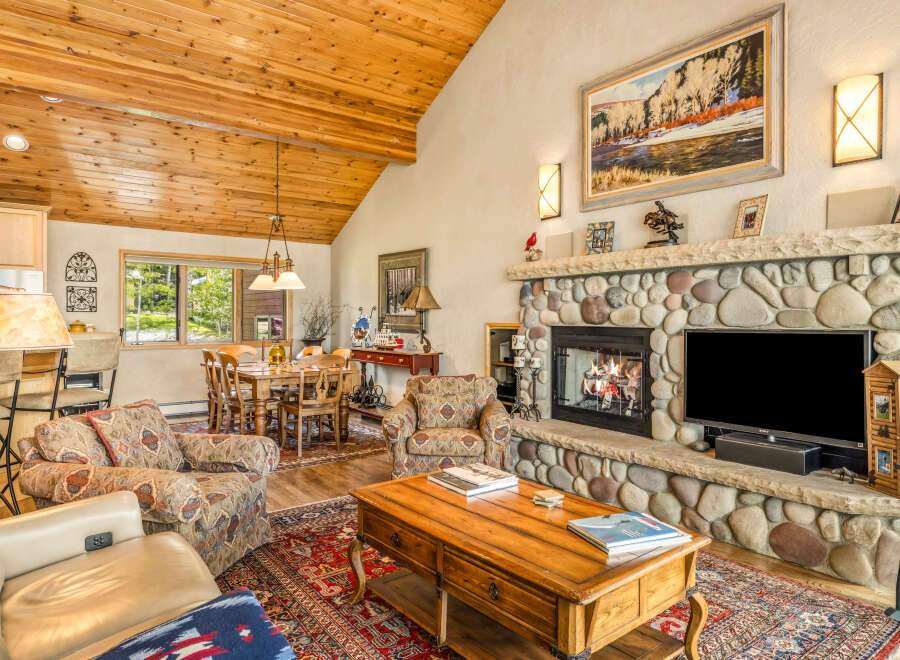This stunning property boasts a cozy living room with a stone fireplace, perfect for relaxing evenings.