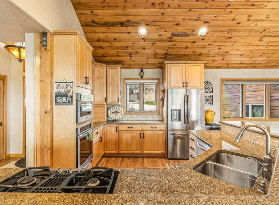 This stunning kitchen boasts a warm and inviting atmosphere with its natural wood cabinets and ceiling.