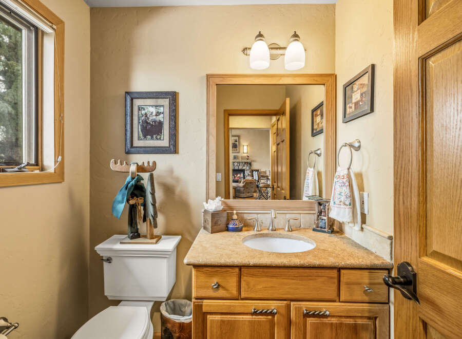 This charming bathroom features a warm, inviting ambiance with its wooden cabinetry and neutral color palette.