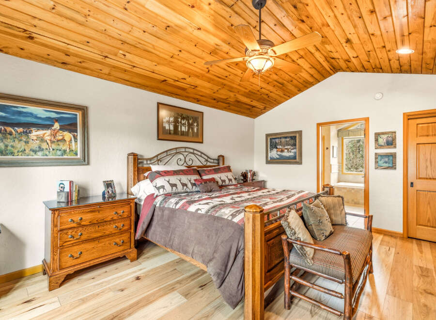 Step into this inviting bedroom, featuring a warm wooden ceiling and flooring that create a cozy atmosphere.