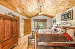 This stunning bedroom boasts a rustic charm with its wooden ceiling and flooring, creating a warm and inviting atmosphere.