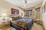 This cozy bedroom features a comfortable bed adorned with a colorful quilt, perfect for a relaxing retreat.