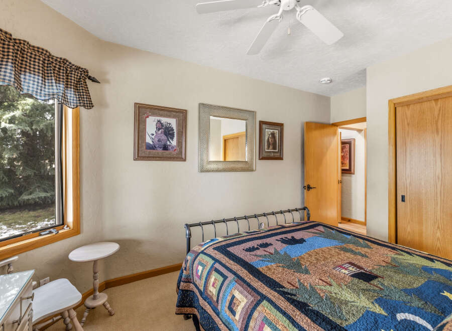 This cozy bedroom features a comfortable bed adorned with a colorful quilt, perfect for a relaxing retreat.