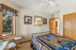 This cozy bedroom features a comfortable bed adorned with a colorful quilt, perfect for a relaxing retreat.