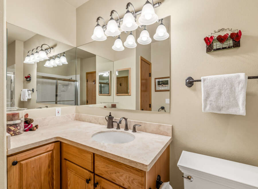 This charming bathroom features a stylish vanity with a marble countertop and a sleek, modern sink.