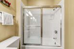 Step into a pristine bathroom featuring a modern glass shower enclosure.