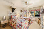 This charming bedroom features two twin beds adorned with cozy, patchwork quilts, perfect for a guest room or a shared space.