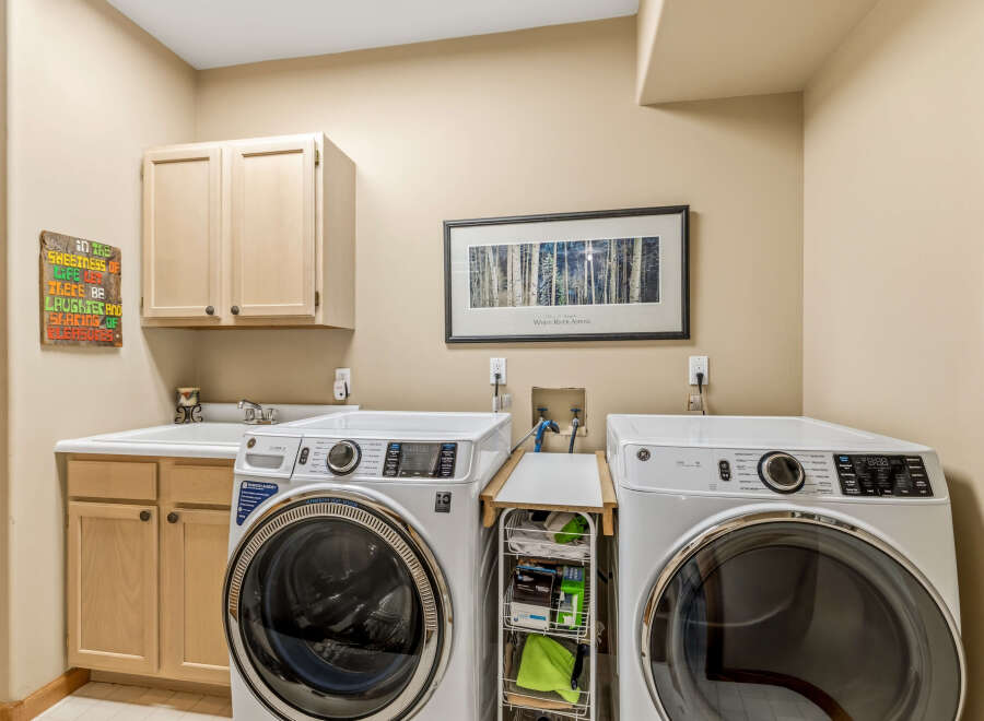 This laundry room features modern appliances and ample storage space, perfect for keeping your home organized.