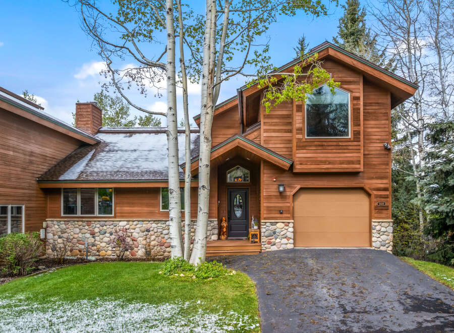 This stunning property boasts a beautiful wooden exterior and a charming stone facade, creating a warm and inviting atmosphere.