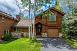 This stunning property boasts a beautiful exterior with wood siding and a stone foundation, offering a warm and inviting aesthetic.