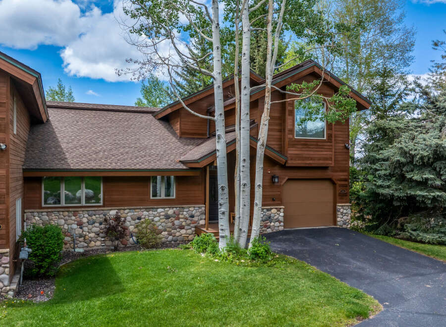This stunning property boasts a beautiful exterior with a combination of wood and stone accents, creating a warm and inviting atmosphere.