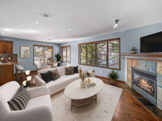 Step into luxury with this stunning living room, featuring a cozy fireplace and a sleek, modern design.