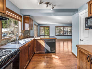 Step into this inviting kitchen, featuring warm wooden cabinetry and sleek appliances.