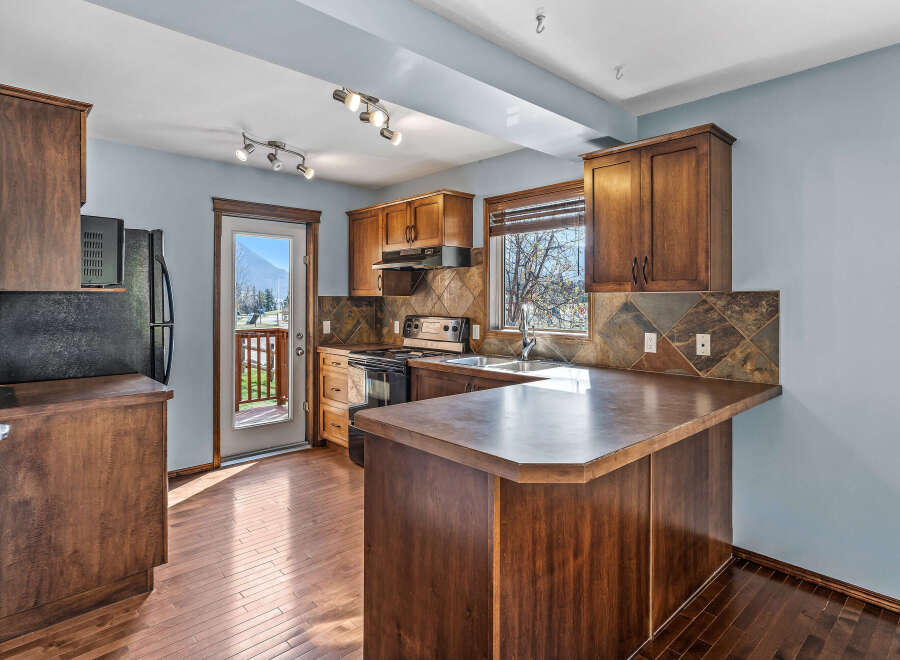 This stunning kitchen boasts rich, dark wood cabinetry and flooring, creating a warm and inviting atmosphere.