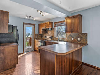 This stunning kitchen boasts rich, dark wood cabinetry and flooring, creating a warm and inviting atmosphere.