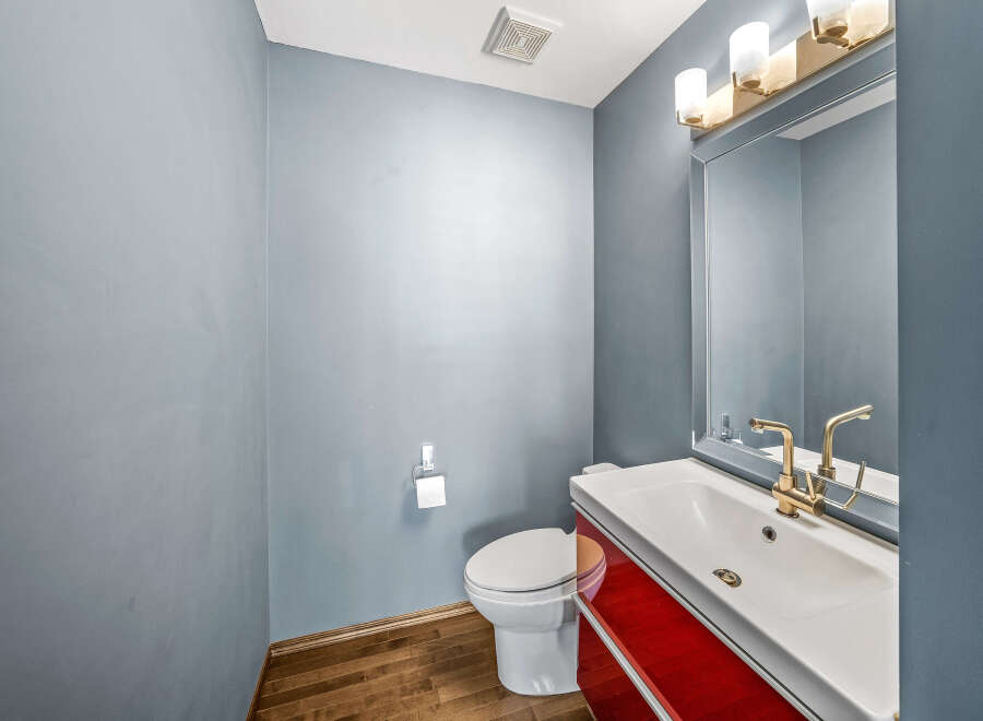 This stunning bathroom features a modern design with a sleek white sink and a vibrant red cabinet.