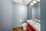 This stunning bathroom features a modern design with a sleek white sink and a vibrant red cabinet.