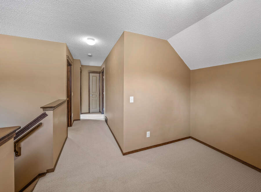 This inviting hallway features neutral tones and ample natural light, creating a warm and welcoming atmosphere.
