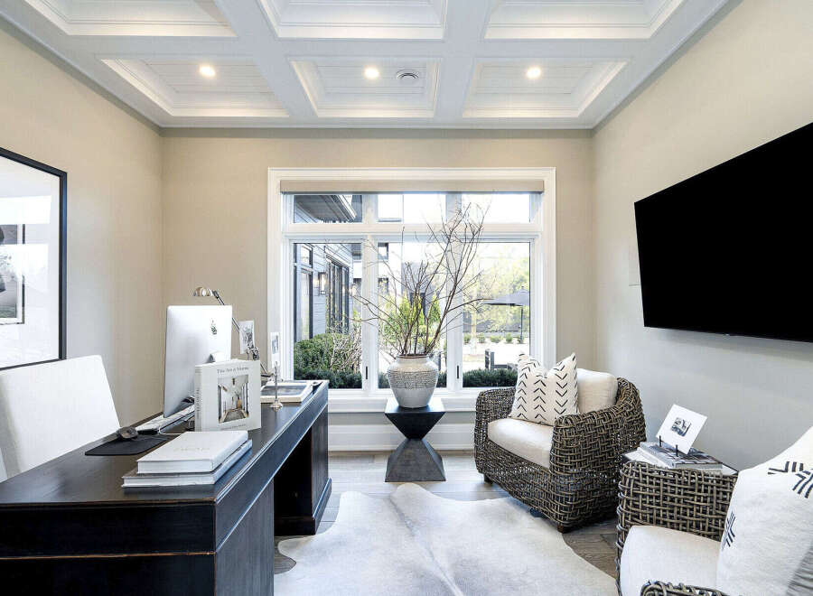 Step into luxury with this stunning home office, featuring a sleek desk and a comfortable seating area.