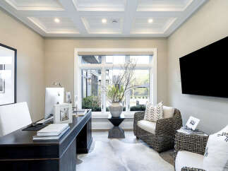 Step into luxury with this stunning home office, featuring a sleek desk and a comfortable seating area.