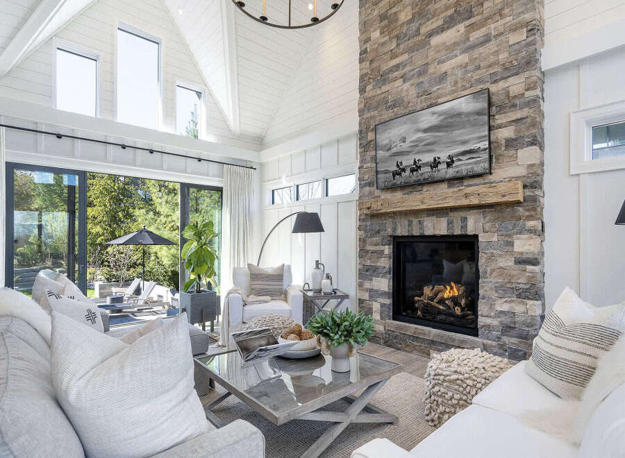 This stunning living room boasts a cozy fireplace with a stone facade, perfect for chilly evenings.