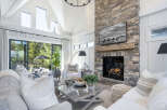 This stunning living room boasts a cozy fireplace with a stone facade, perfect for chilly evenings.