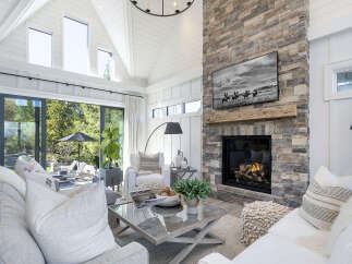 This stunning living room boasts a cozy fireplace with a stone facade, perfect for chilly evenings.