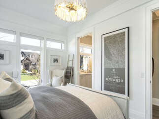 This stunning bedroom boasts a bright and airy ambiance, enhanced by large windows that flood the space with natural light.