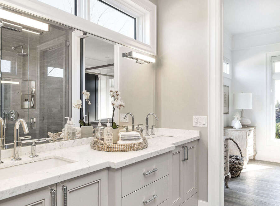 This luxurious bathroom boasts a modern design with a sleek vanity and ample counter space.