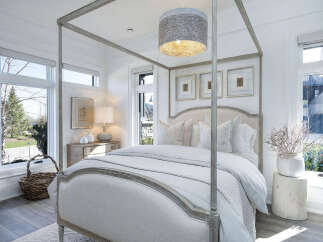 Step into a serene bedroom retreat, where natural light floods through expansive windows, illuminating the elegant four-poster bed.