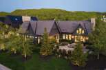 Experience luxury living in this stunning modern home, nestled against a backdrop of lush green hills.