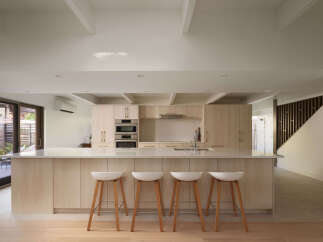 This modern kitchen boasts a sleek design with light wood cabinetry and a spacious island.