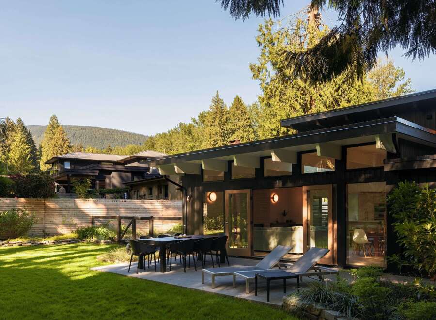This stunning property boasts a modern design with sleek lines and a dark exterior, creating a sophisticated aesthetic.