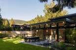 This stunning property boasts a modern design with sleek lines and a dark exterior, creating a sophisticated aesthetic.