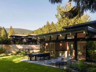 This stunning property boasts a modern design with sleek lines and a dark exterior, creating a sophisticated aesthetic.