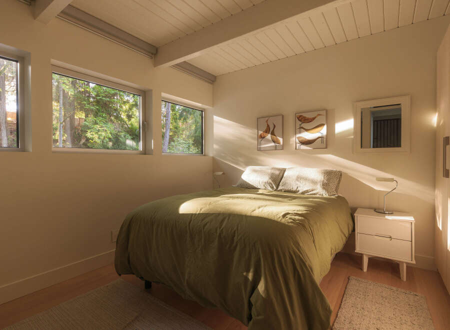 This serene bedroom offers a tranquil retreat with its minimalist design and natural light.
