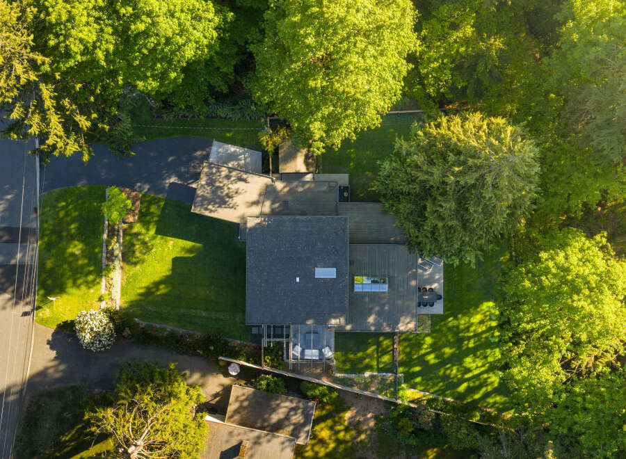 This stunning property boasts a modern architectural design, seamlessly blending with its lush, green surroundings.